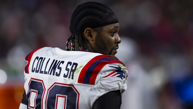 Patriots linebacker Jamie Collins looks on without a helmet during a game.